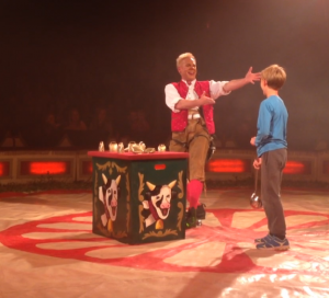 Bild på en clown och en pojke under ett cirkusnummer